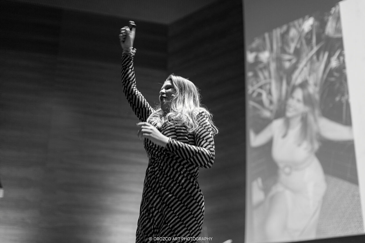 Ponente inspirando a la audiencia con energía en Mujeres Brillantes