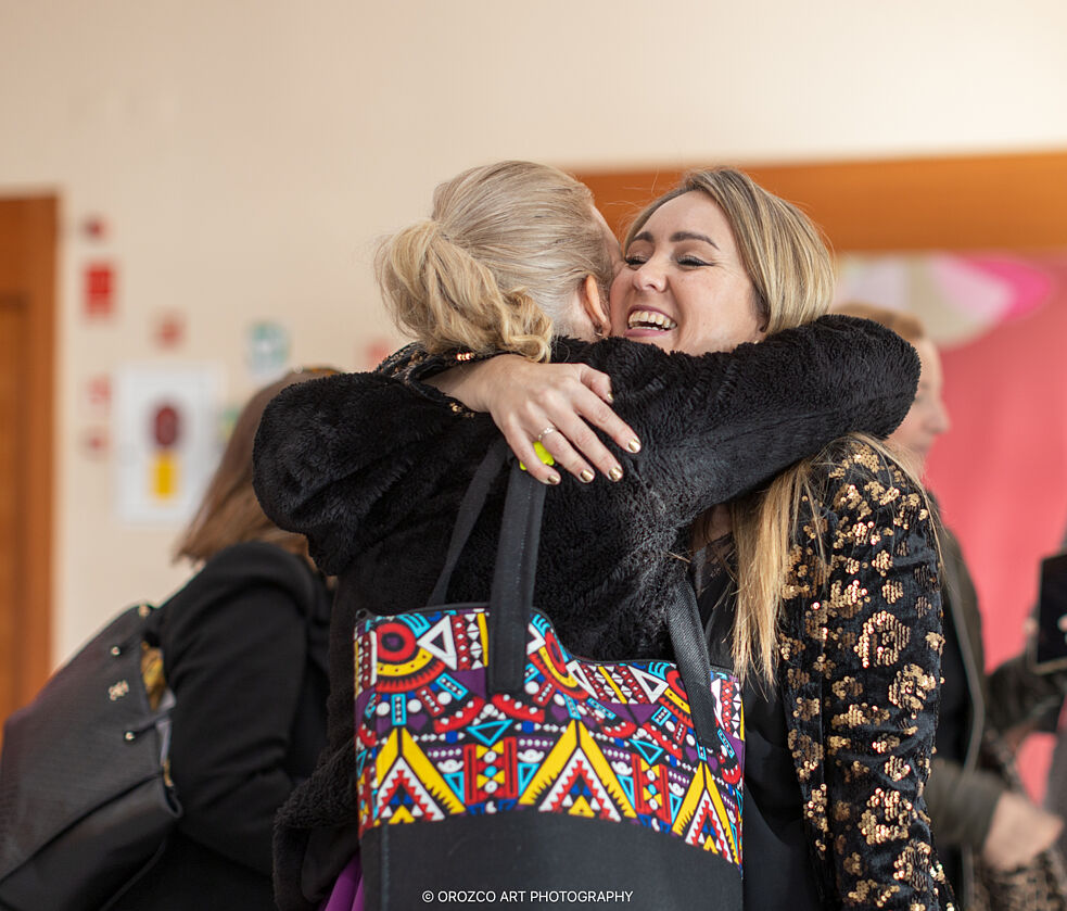 Asistentes abrazándose durante el networking de Mujeres Brillantes